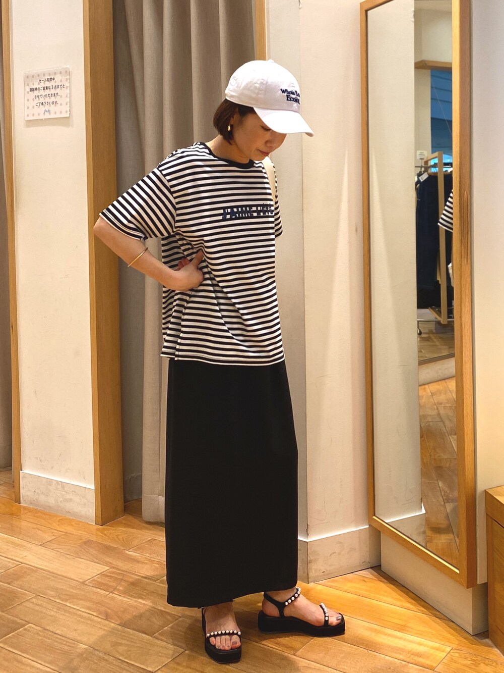 ブラック系のスカート、ホワイト系のTシャツ/カットソー、ホワイト系のショルダーバッグを着用したレディースの夏コーディネートの4枚目の写真