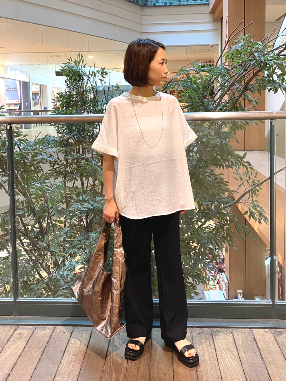 ホワイト系のシャツ/ブラウス、ブラック系のその他パンツ、シルバー系のトートバッグを着用したレディースの夏コーディネートの2枚目の写真