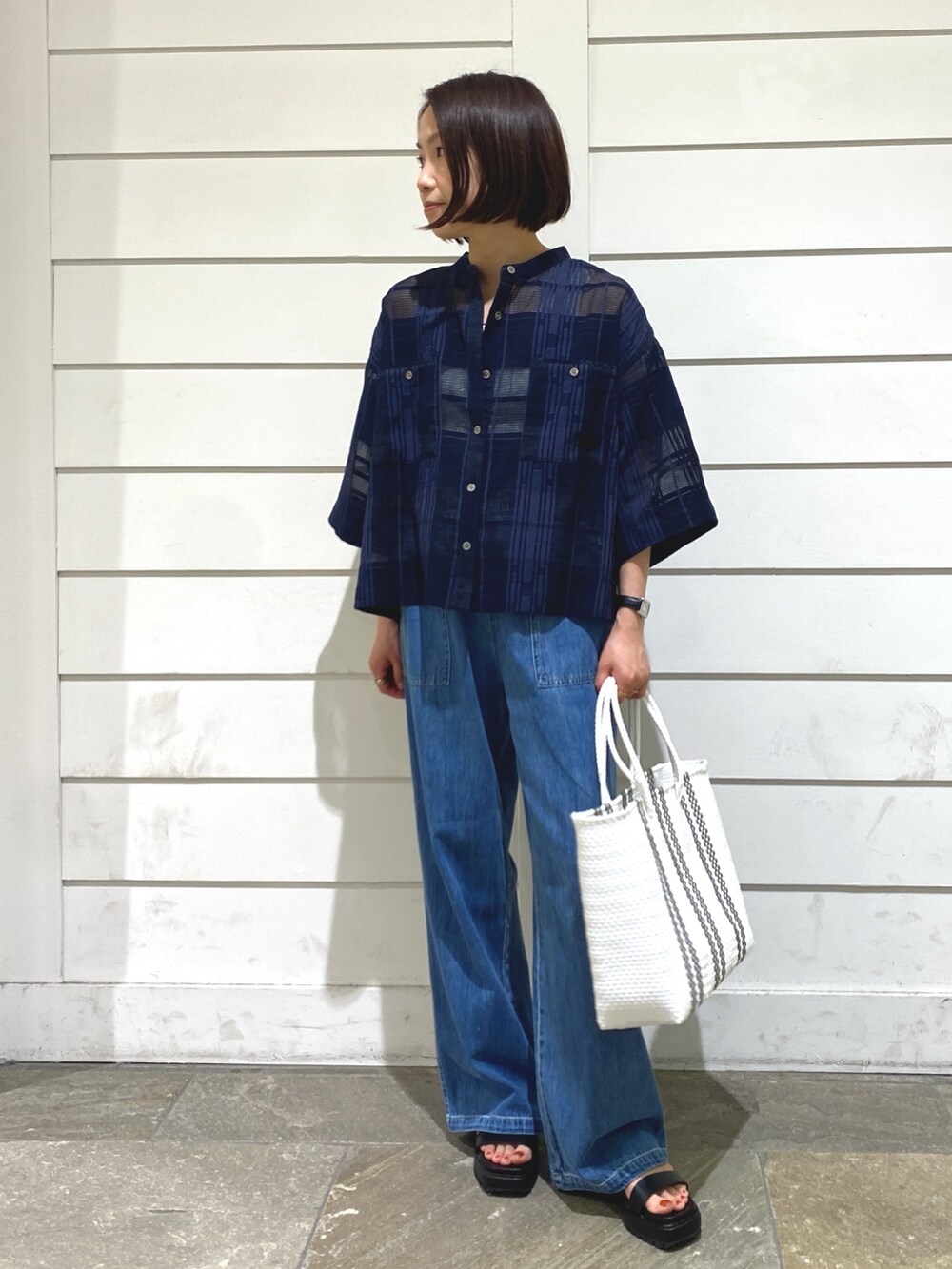 ブルー系のデニムパンツ、ブルー系のシャツ/ブラウス、ホワイト系のタンクトップを着用したレディースの夏コーディネートの3枚目の写真