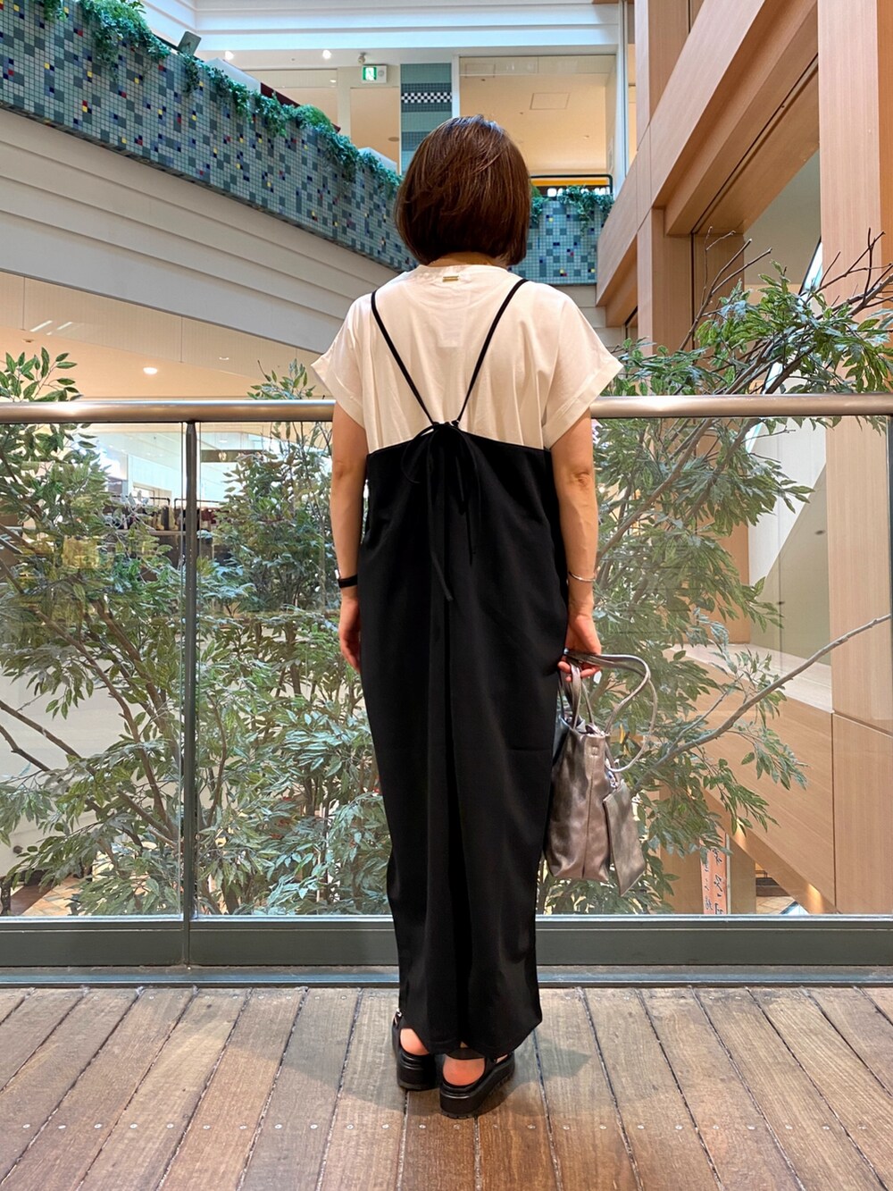 ブラック系のワンピース、シルバー系のショルダーバッグ、ホワイト系のTシャツ/カットソーを着用したレディースの夏コーディネートの5枚目の写真