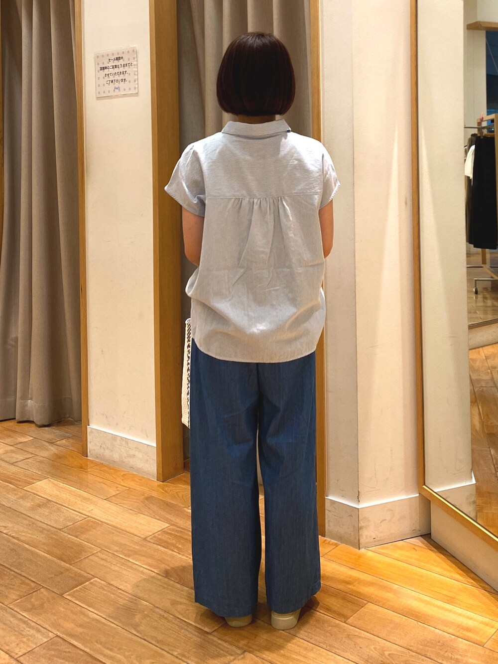 ブルー系のデニムパンツ、ホワイト系のかごバッグ、ブルー系のシャツ/ブラウスを着用したレディースの夏コーディネートの6枚目の写真