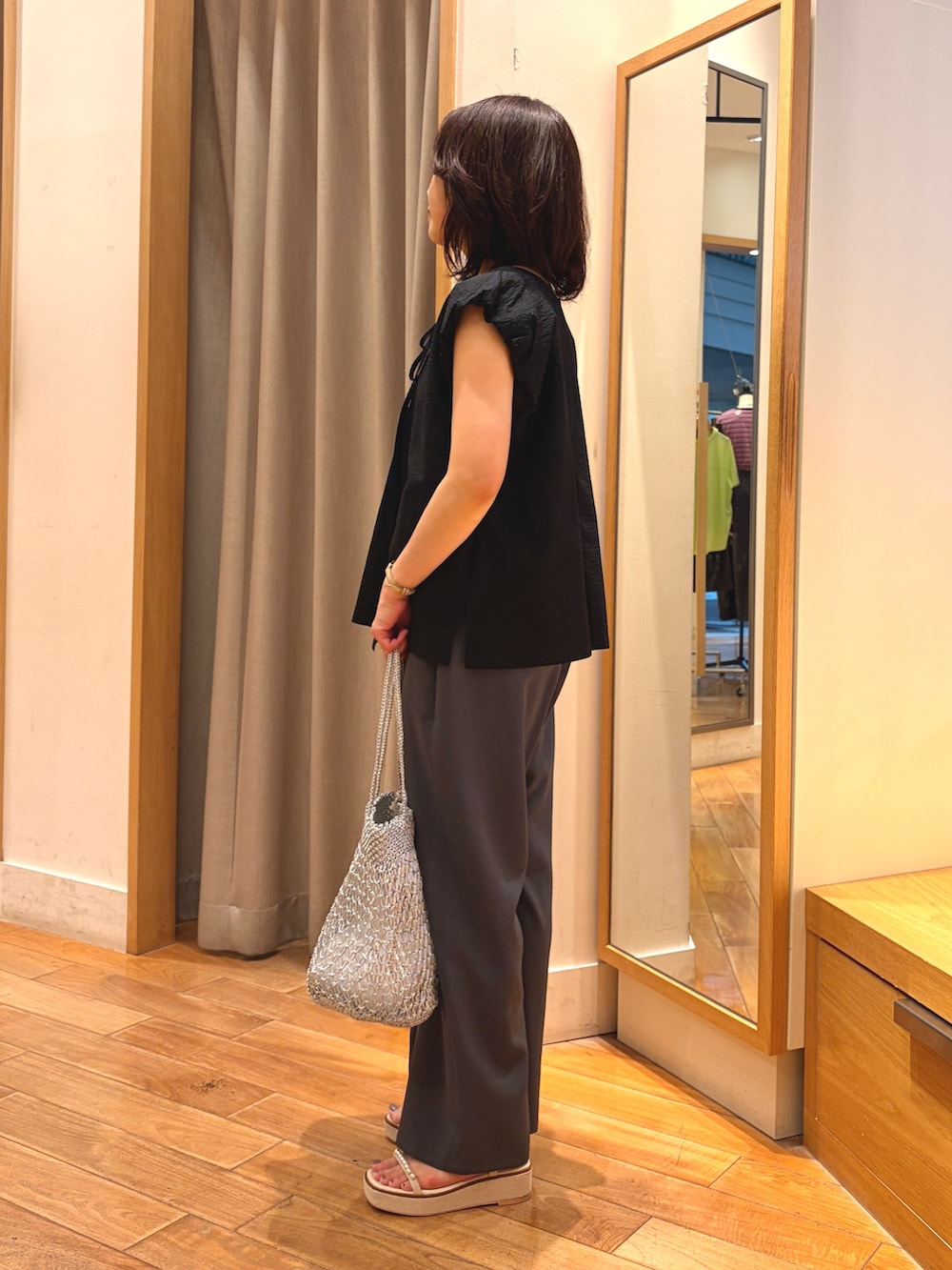 ブラック系のシャツ/ブラウス、グレー系のその他パンツ、シルバー系のかごバッグを着用したレディースの夏コーディネートの7枚目の写真