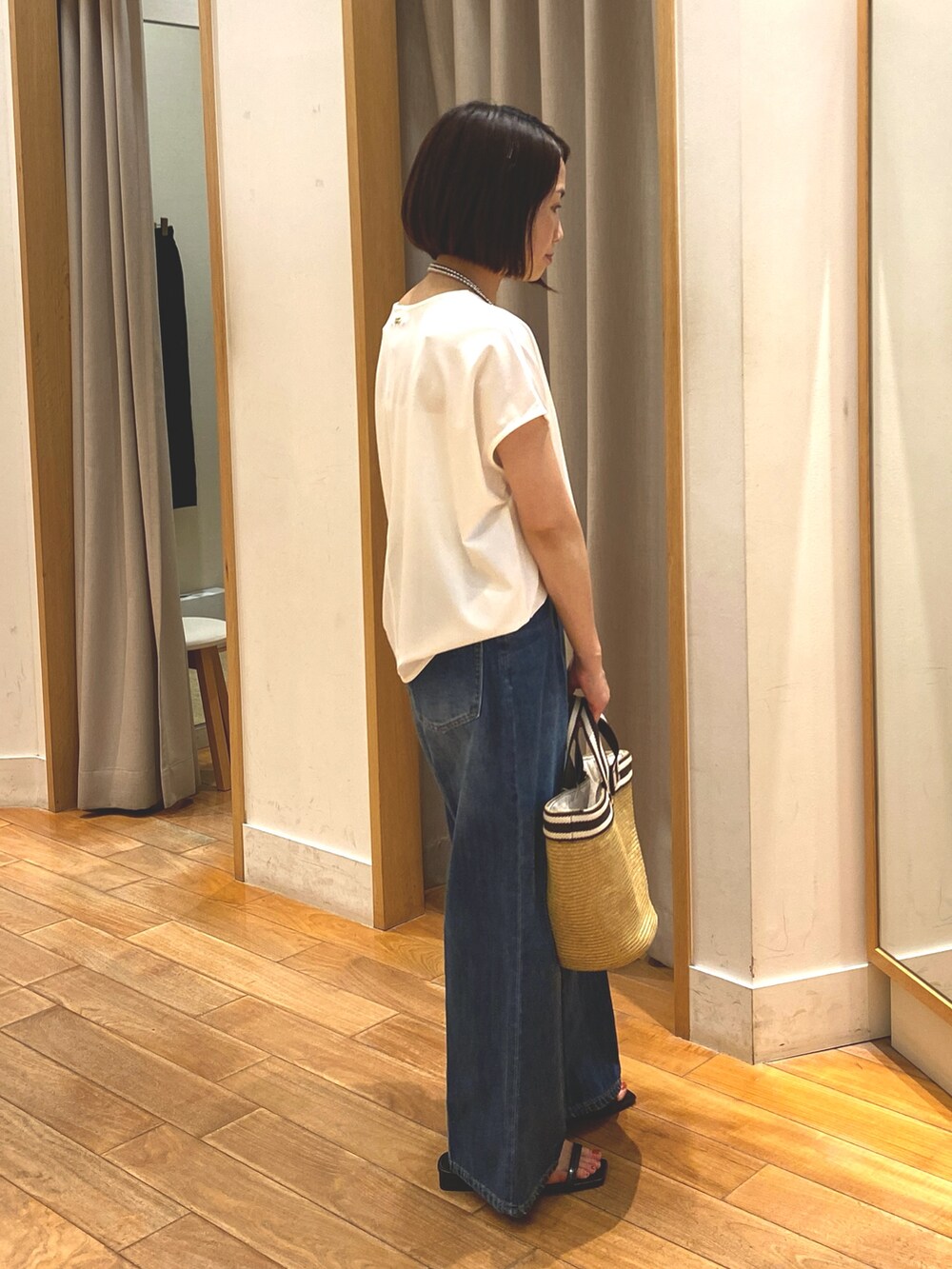 ブルー系のデニムパンツ、ホワイト系のTシャツ/カットソー、ベージュ系のかごバッグを着用したレディースの夏コーディネートの7枚目の写真