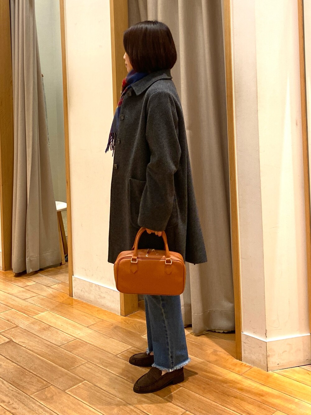 グレー系のダッフルコート、ブルー系のニット/セーター、ブルー系のデニムパンツを着用したレディースの冬コーディネートの4枚目の写真