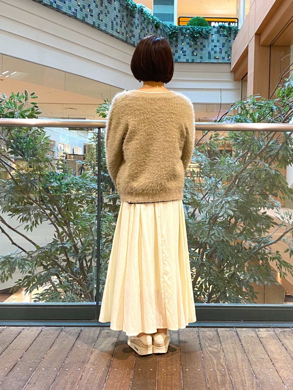 ベージュ系のカーディガン/ボレロ、ホワイト系のTシャツ/カットソー、ホワイト系のスカートを着用したレディースの秋コーディネートの6枚目の写真