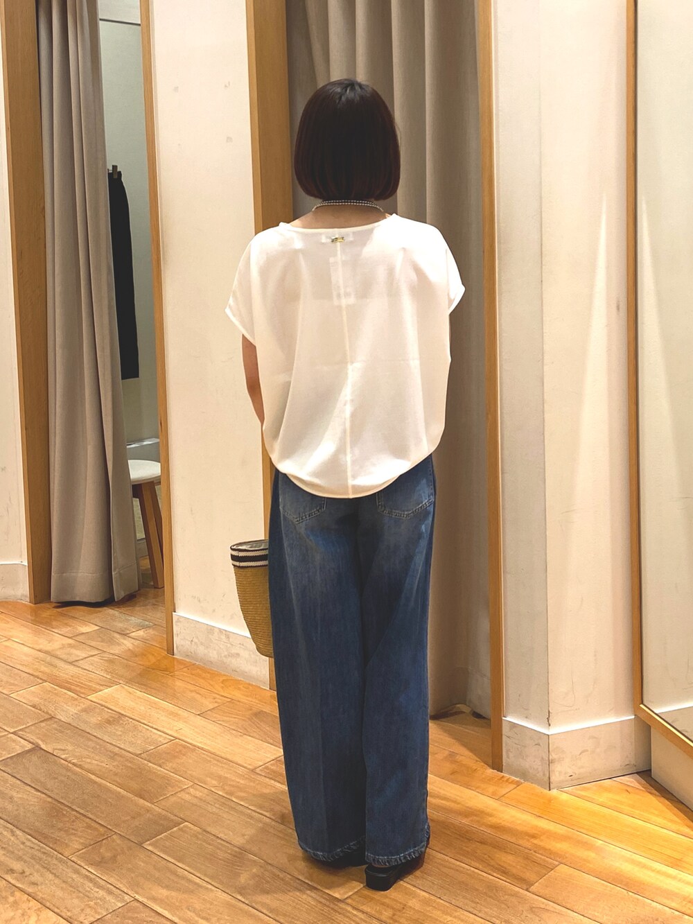 ブルー系のデニムパンツ、ホワイト系のTシャツ/カットソー、ベージュ系のかごバッグを着用したレディースの夏コーディネートの8枚目の写真