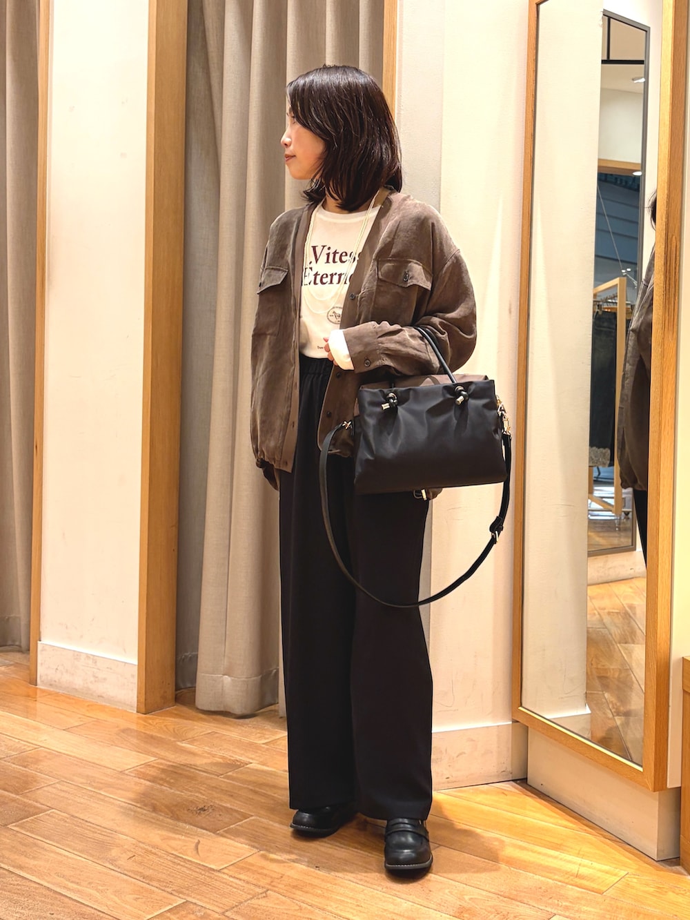 ブラック系のその他パンツ、ホワイト系のTシャツ/カットソー、ブラック系のボストンバッグを着用したレディースの秋コーディネートの2枚目の写真