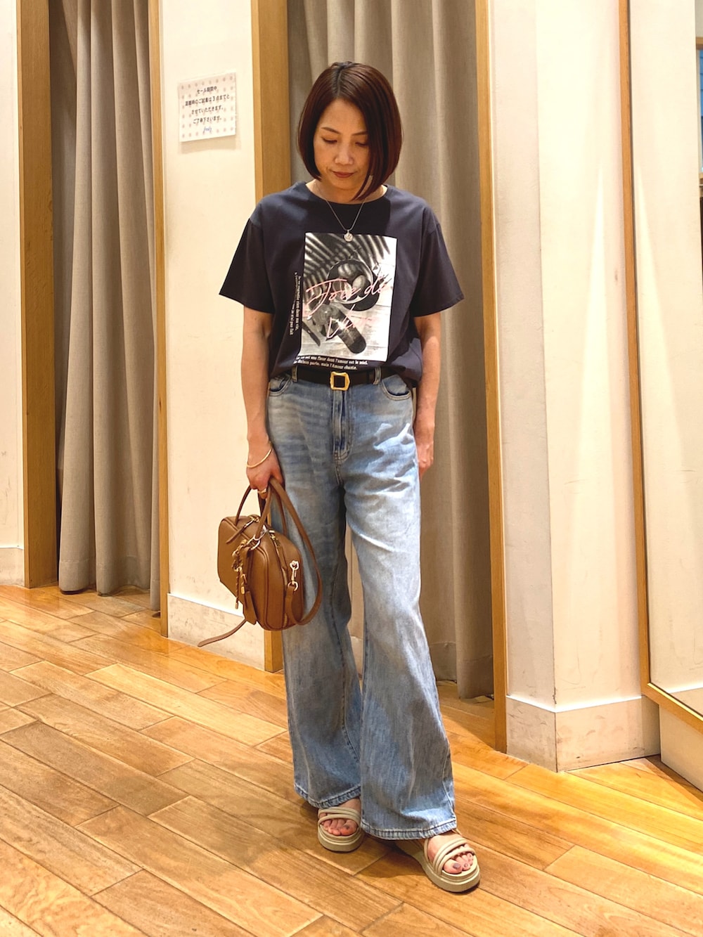 イエロー系のショルダーバッグ、ブルー系のデニムパンツ、グレー系のTシャツ/カットソーを着用したレディースの夏コーディネートの2枚目の写真