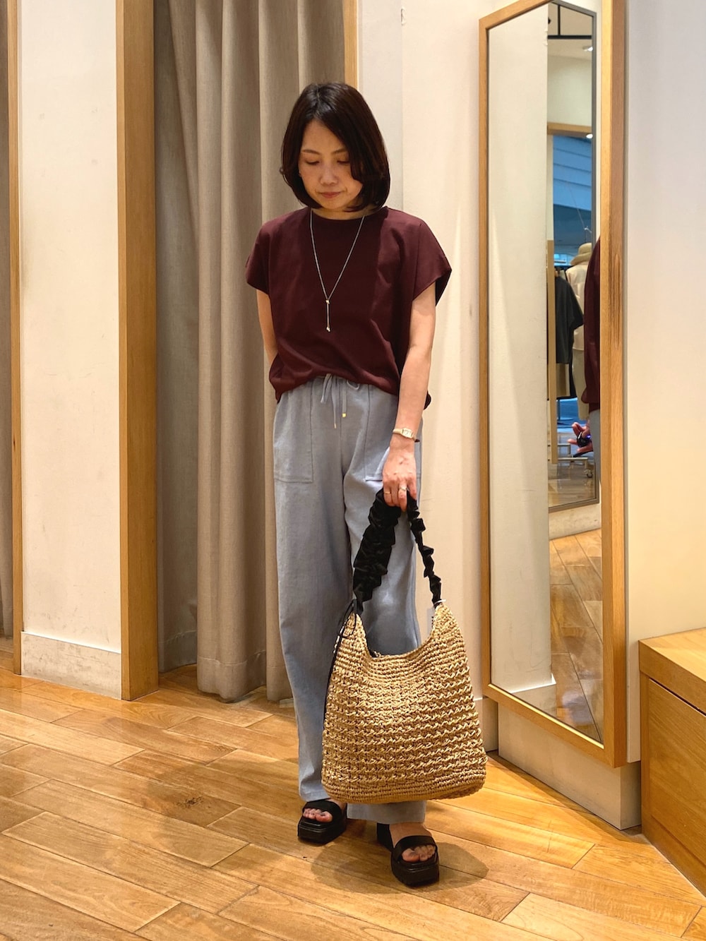 ブラウン系のTシャツ/カットソー、ブラック系のショルダーバッグ、ゴールド系のネックレスを着用したレディースの夏コーディネートの4枚目の写真