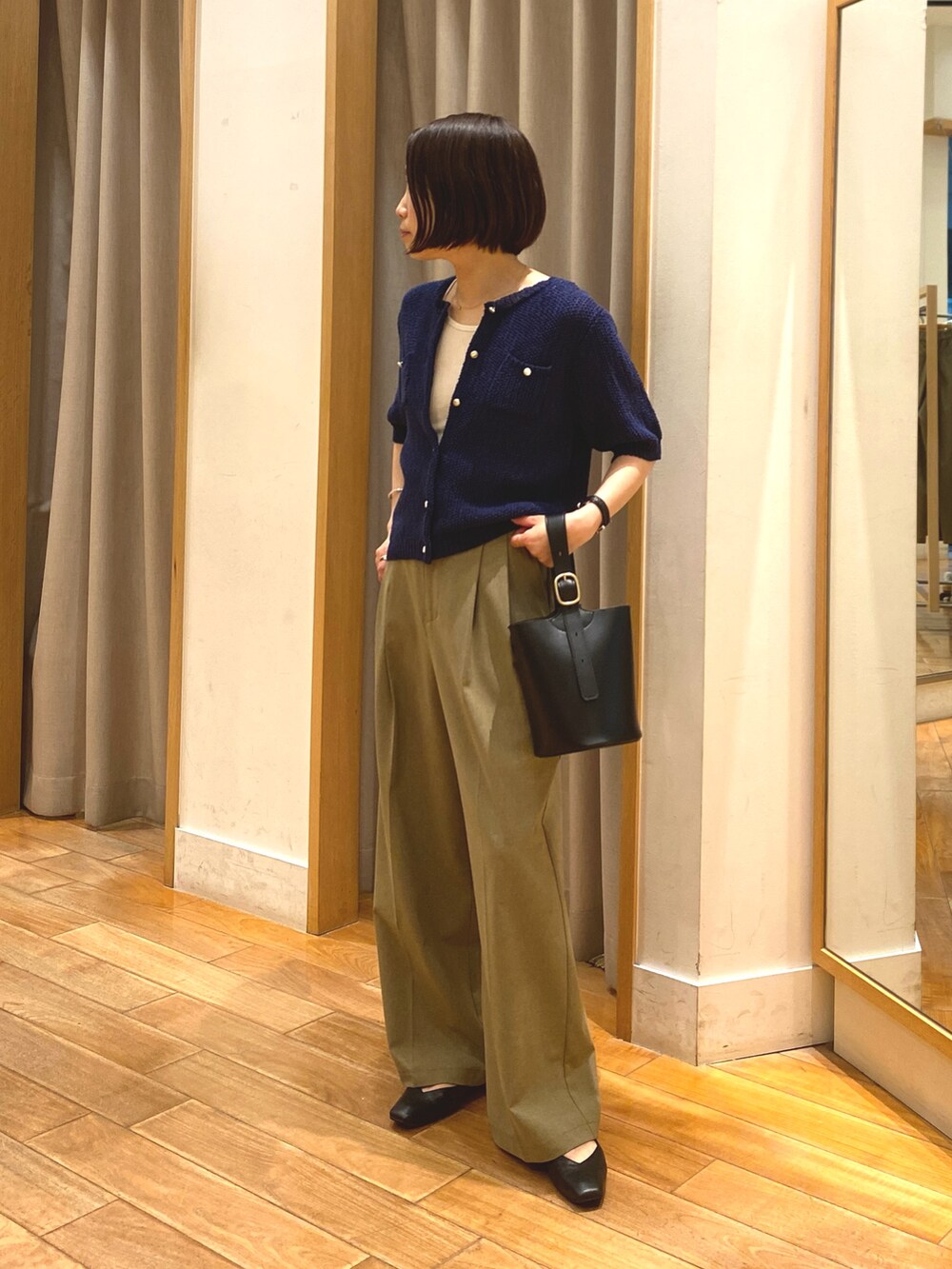 ブルー系のカーディガン/ボレロ、ホワイト系のTシャツ/カットソー、イエロー系のスラックスを着用したレディースの春コーディネートの2枚目の写真
