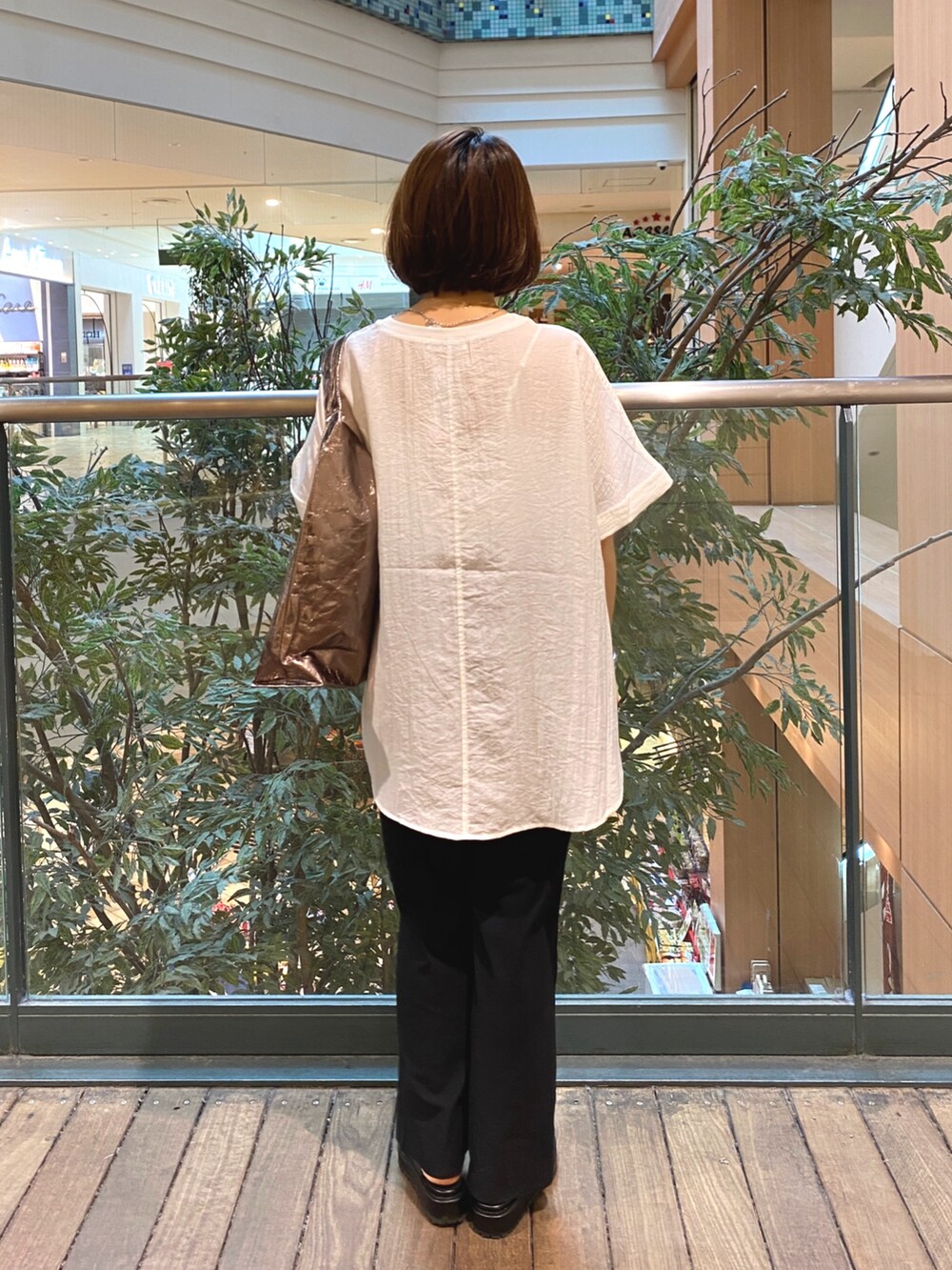 ホワイト系のシャツ/ブラウス、ブラック系のその他パンツ、シルバー系のトートバッグを着用したレディースの夏コーディネートの6枚目の写真