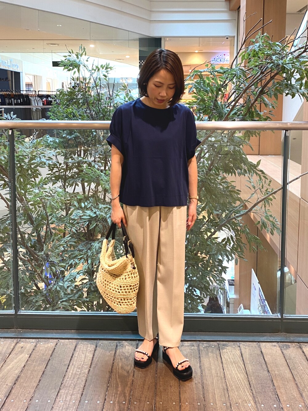 ブルー系のTシャツ/カットソー、ベージュ系のかごバッグ、ベージュ系のその他パンツを着用したレディースの夏コーディネートの3枚目の写真