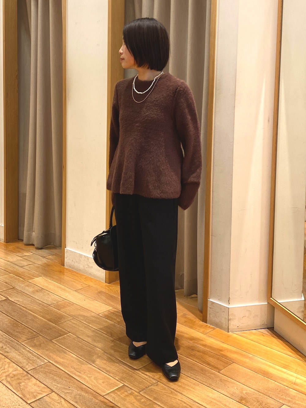ブラック系のその他パンツ、ブラック系のショルダーバッグ、ブラウン系のニット/セーターを着用したレディースの冬コーディネートの2枚目の写真
