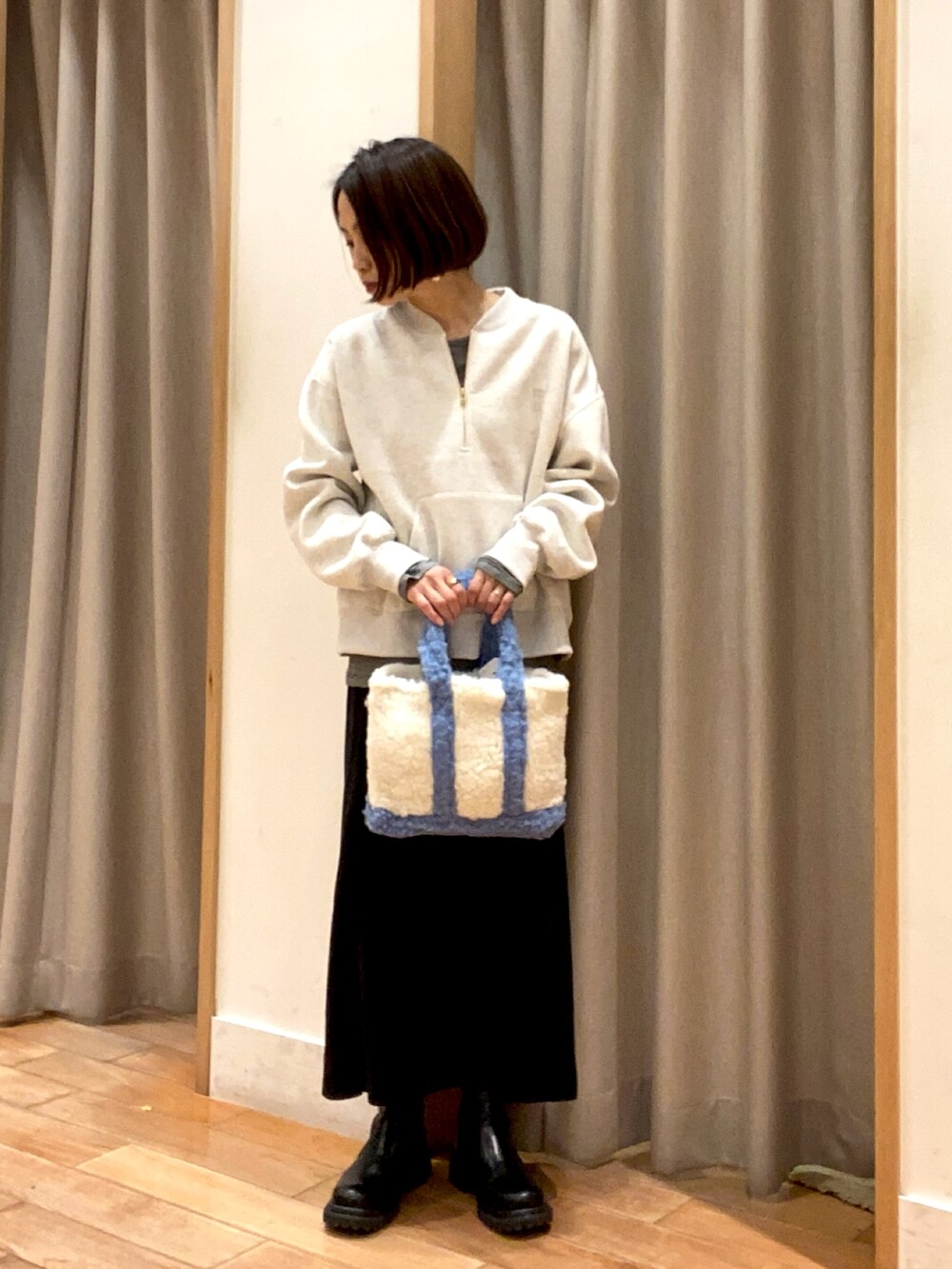 グレー系のスウェット、ブラック系のTシャツ/カットソー、ブラック系のスカートを着用したレディースの冬コーディネートの2枚目の写真