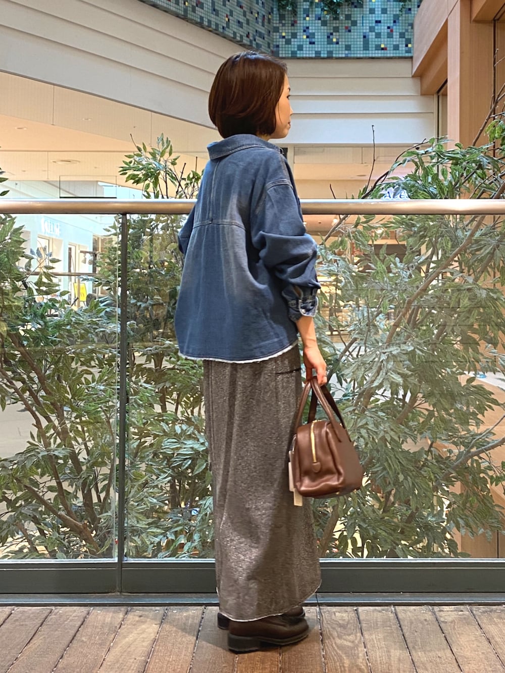 ブルー系のシャツ/ブラウス、グレー系のスカート、ホワイト系のTシャツ/カットソーを着用したレディースの秋コーディネートの3枚目の写真