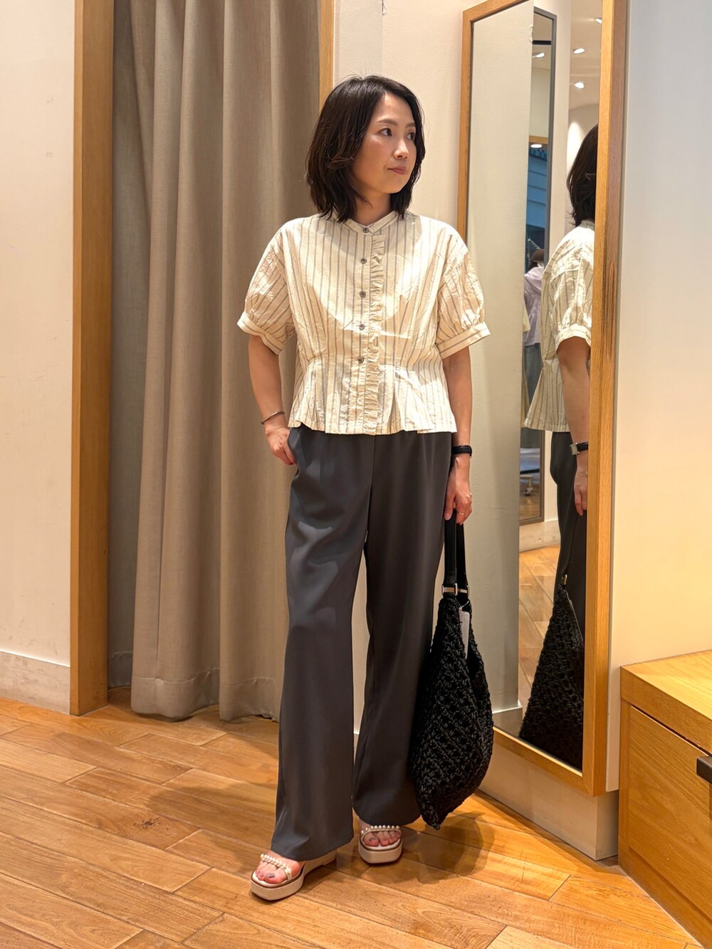 グレー系のその他パンツ、ホワイト系のシャツ/ブラウス、ブラック系のショルダーバッグを着用したレディースの夏コーディネートの2枚目の写真