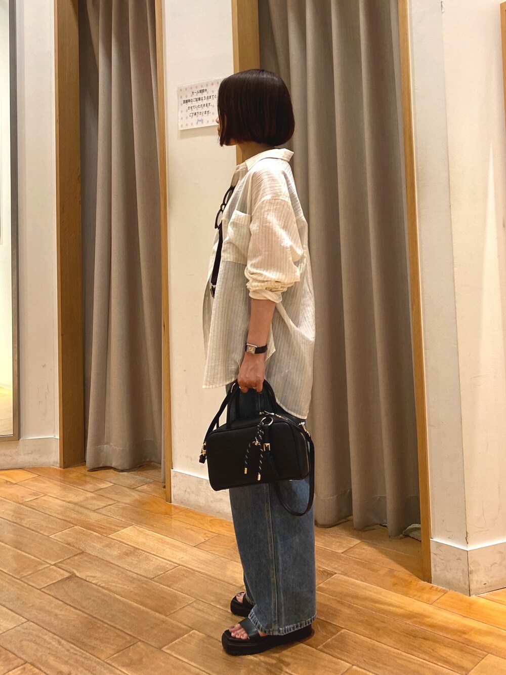 ブルー系のデニムパンツ、ブラック系のショルダーバッグ、ホワイト系のシャツ/ブラウスを着用したレディースの夏コーディネートの7枚目の写真