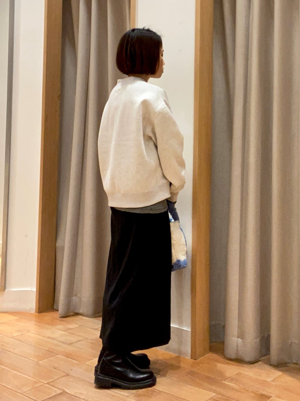 グレー系のスウェット、ブラック系のTシャツ/カットソー、ブラック系のスカートを着用したレディースの冬コーディネートの4枚目の写真