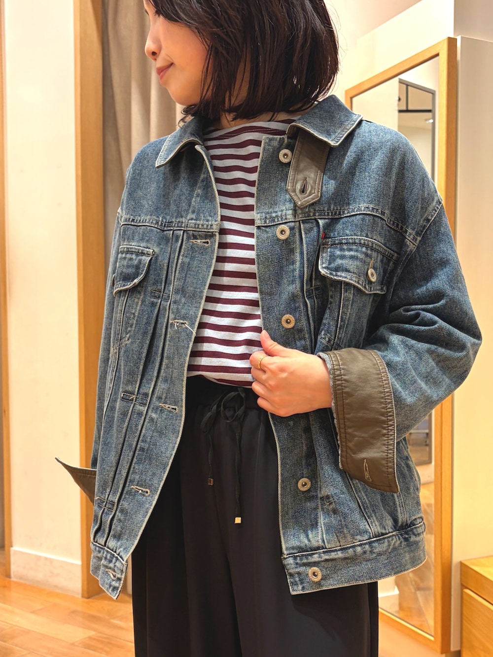 ブラック系のその他パンツ、ブルー系のデニムジャケット、ブルー系のTシャツ/カットソーを着用したレディースの秋コーディネートの3枚目の写真
