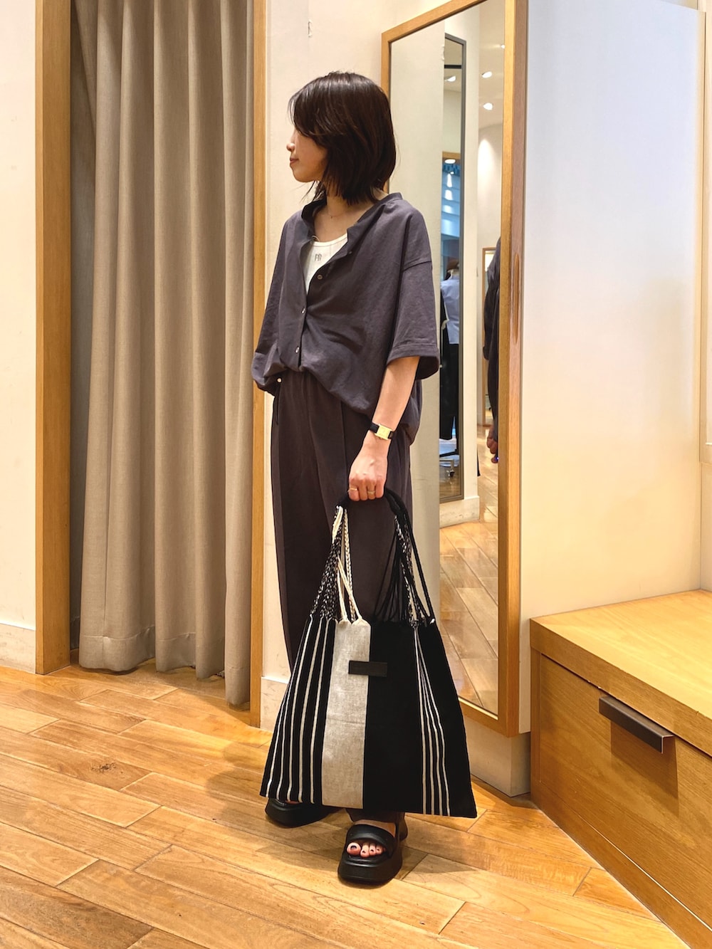 グレー系のその他パンツ、ホワイト系のトートバッグ、グレー系のシャツ/ブラウスを着用したレディースの夏コーディネートの2枚目の写真