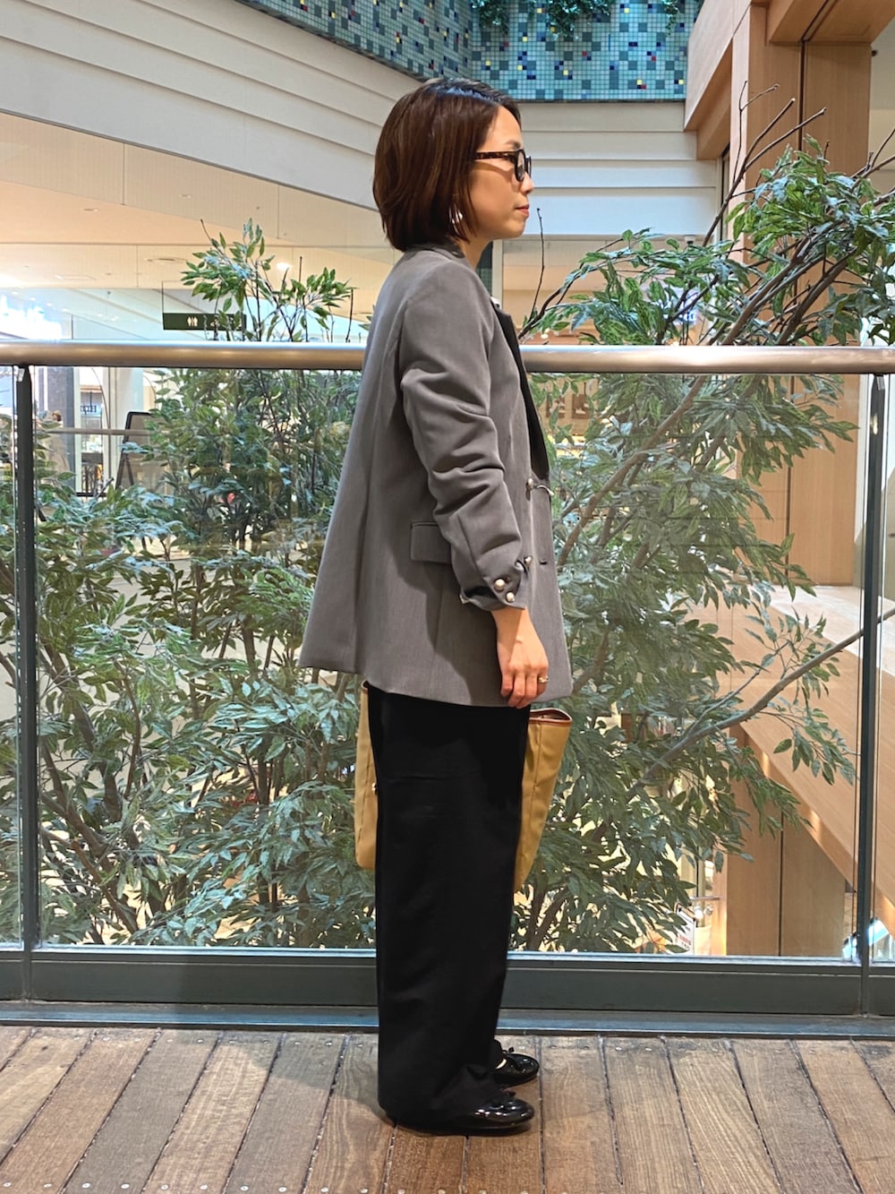 グレー系のテーラードジャケット、ホワイト系のTシャツ/カットソー、ブラック系のチノパンツを着用したレディースの秋コーディネートの4枚目の写真