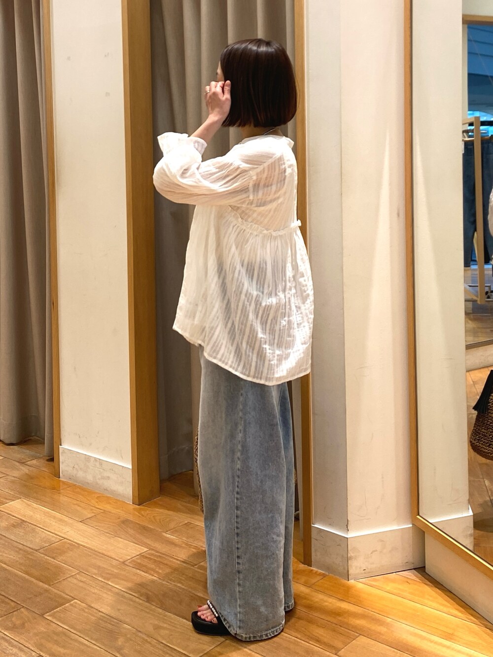 ホワイト系のシャツ/ブラウス、ブラウン系のかごバッグ、ブルー系のデニムパンツを着用したレディースの夏コーディネートの4枚目の写真