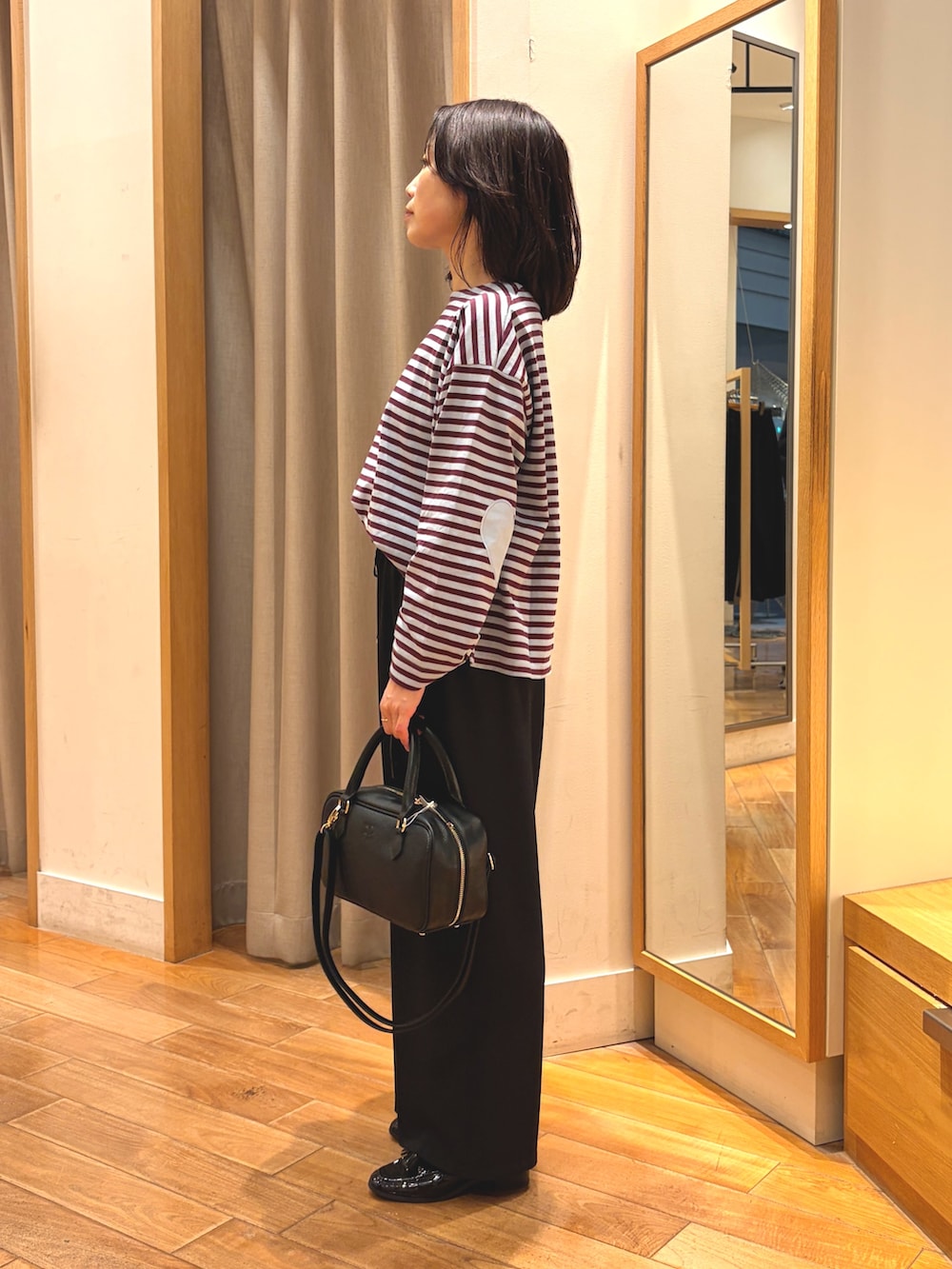 ブラック系のその他パンツ、ブルー系のTシャツ/カットソー、ブラック系のボストンバッグを着用したレディースの秋コーディネートの5枚目の写真