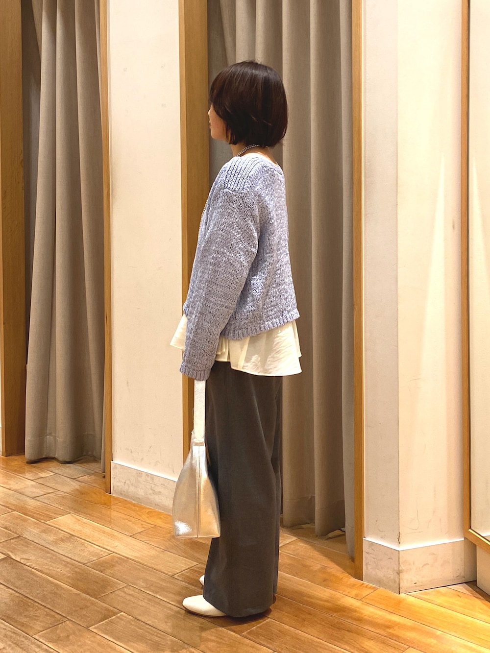 グレー系のその他パンツ、ホワイト系のシャツ/ブラウス、ブルー系のニット/セーターを着用したレディースの春コーディネートの5枚目の写真