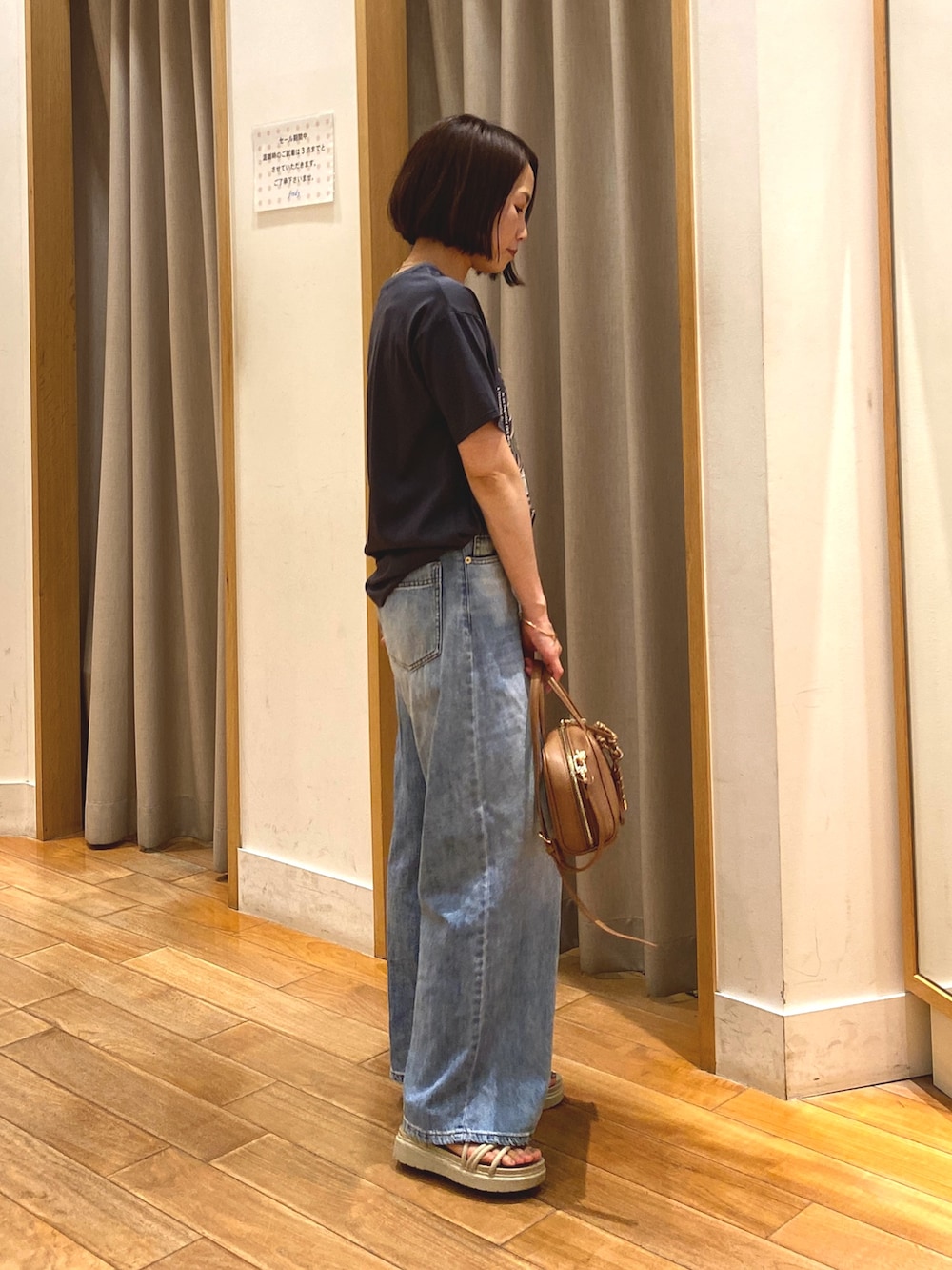 イエロー系のショルダーバッグ、ブルー系のデニムパンツ、グレー系のTシャツ/カットソーを着用したレディースの夏コーディネートの4枚目の写真