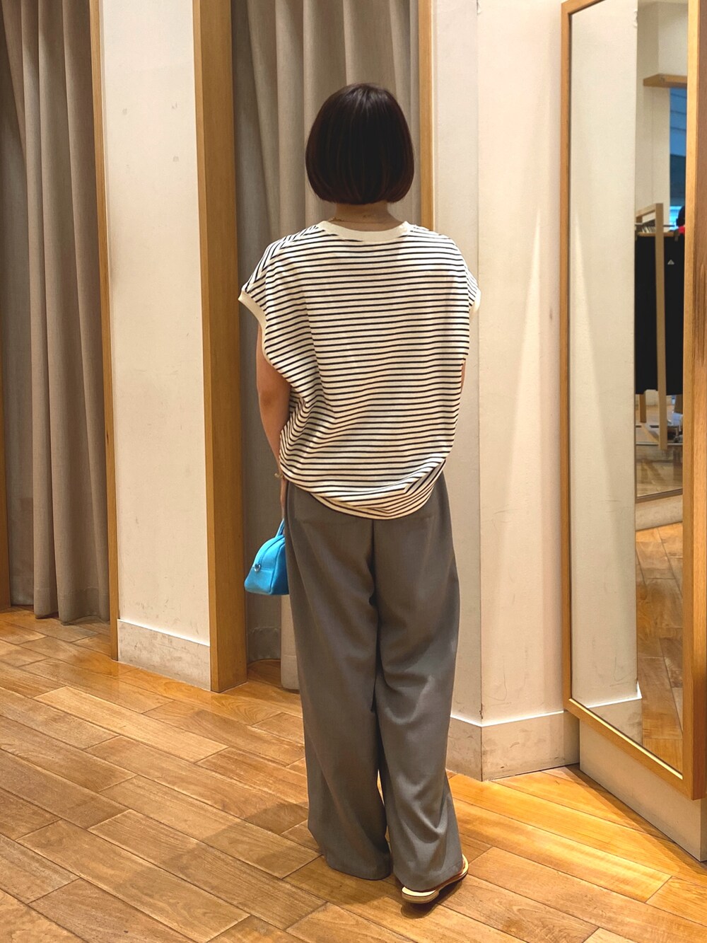 ブルー系のTシャツ/カットソー、ベージュ系のかごバッグ、グレー系のその他パンツを着用したレディースの春コーディネートの4枚目の写真