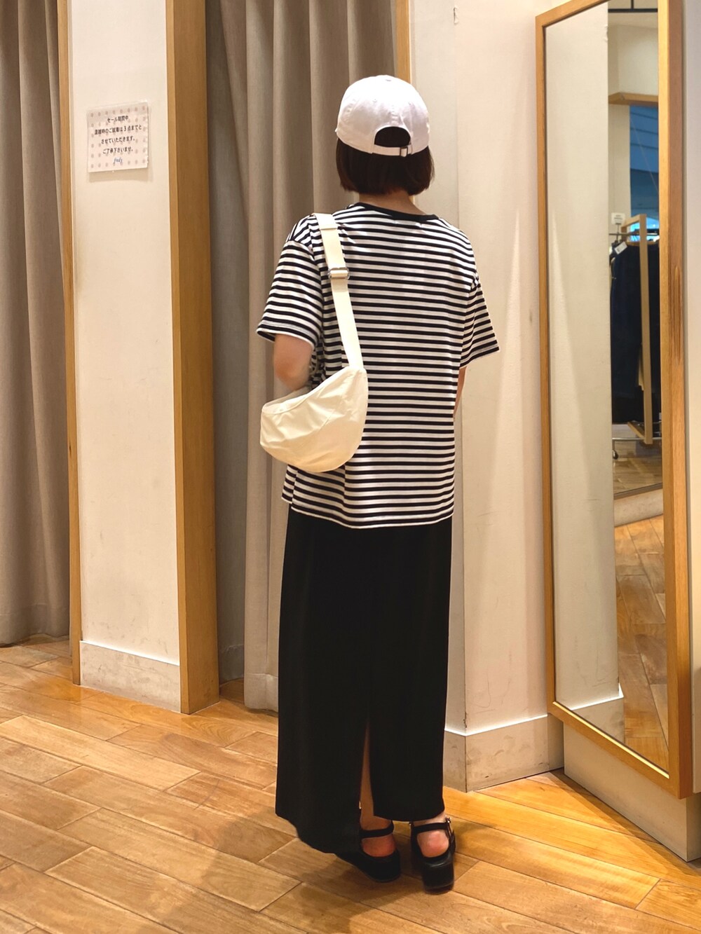 ブラック系のスカート、ホワイト系のTシャツ/カットソー、ホワイト系のショルダーバッグを着用したレディースの夏コーディネートの6枚目の写真