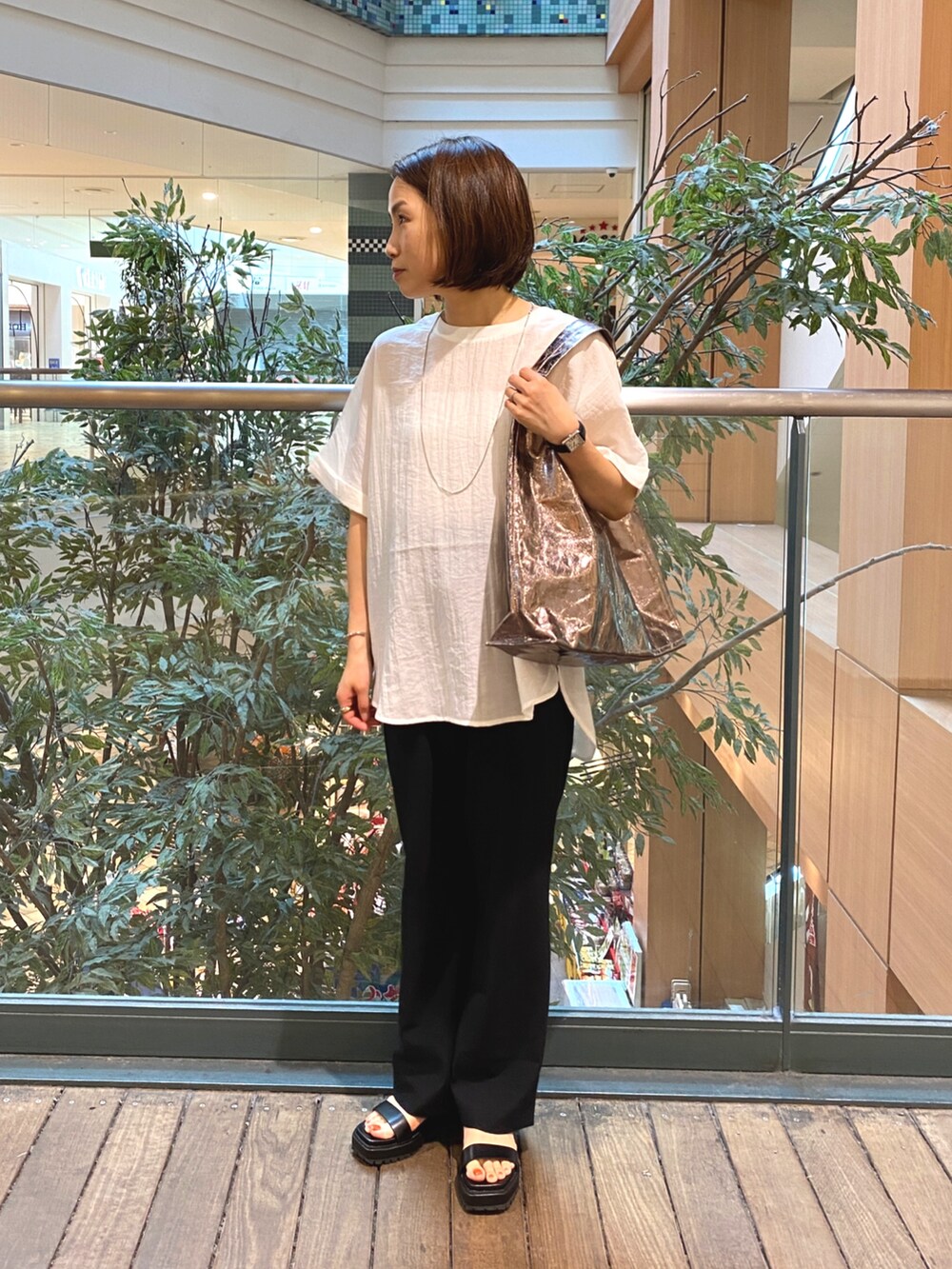 ホワイト系のシャツ/ブラウス、ブラック系のその他パンツ、シルバー系のトートバッグを着用したレディースの夏コーディネートの3枚目の写真