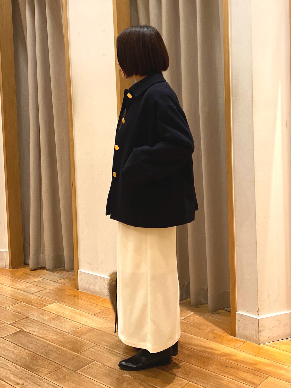 ブルー系のダッフルコート、ブラウン系のニット/セーター、ホワイト系のTシャツ/カットソーを着用したレディースの冬コーディネートの4枚目の写真