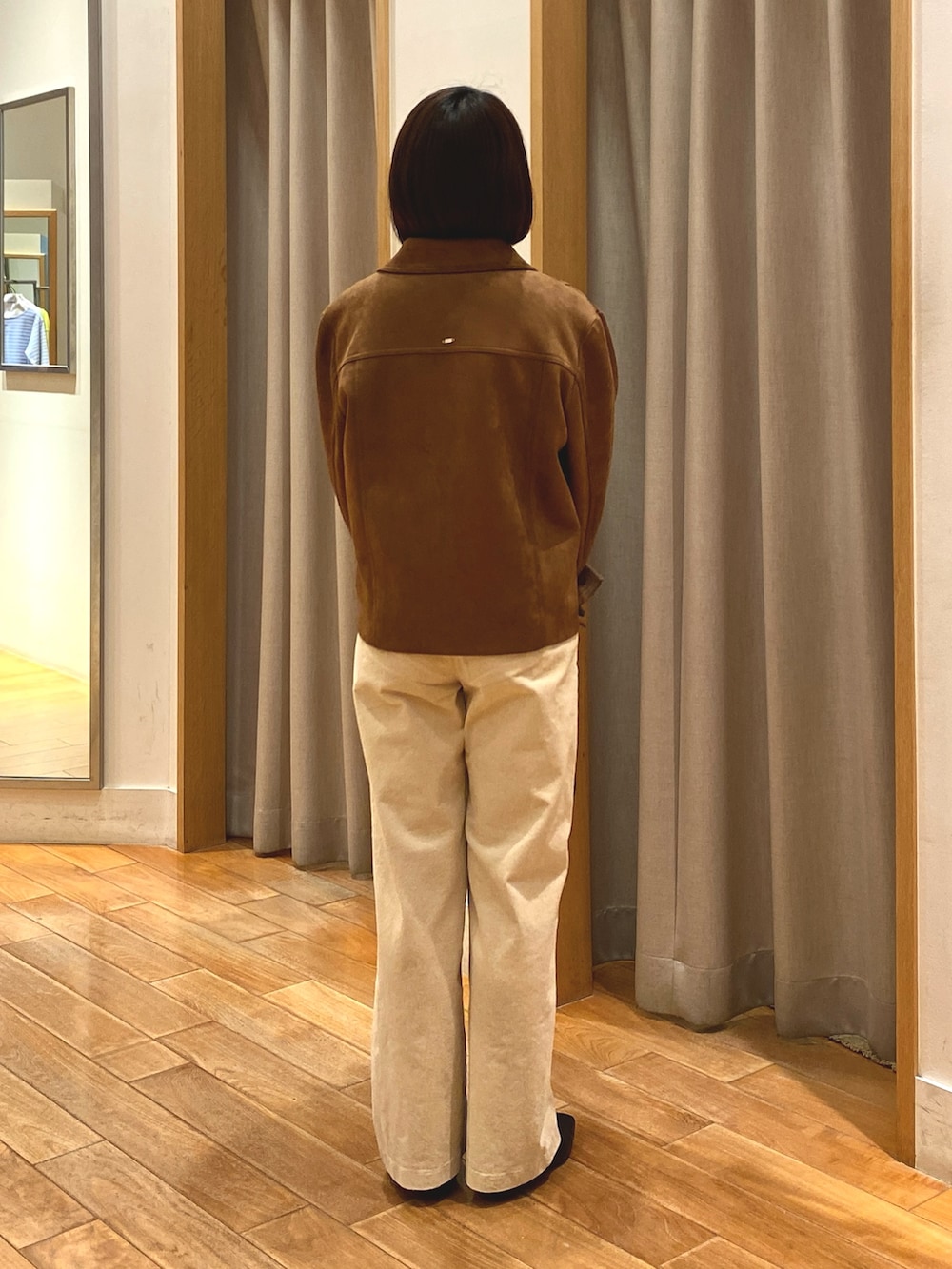 ブラウン系のダウンジャケット/コート、ホワイト系のニット/セーター、ブラウン系のショルダーバッグを着用したレディースの秋コーディネートの7枚目の写真