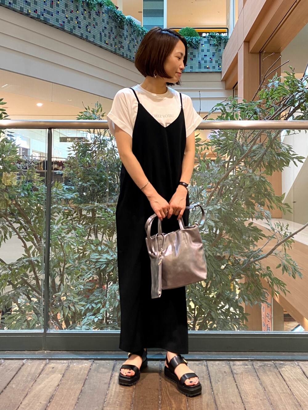 ブラック系のワンピース、シルバー系のショルダーバッグ、ホワイト系のTシャツ/カットソーを着用したレディースの夏コーディネートの2枚目の写真