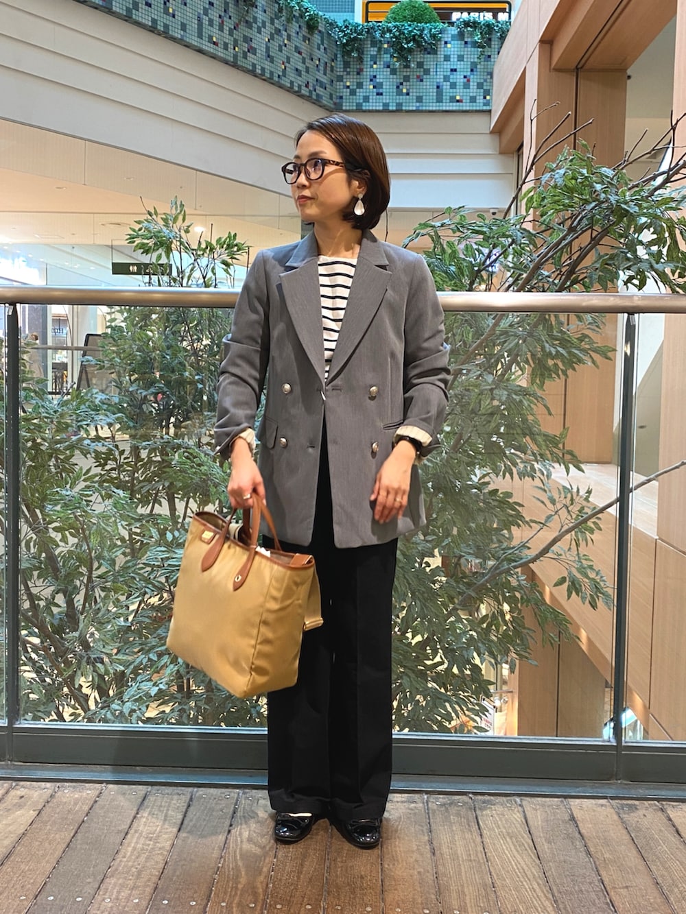 グレー系のテーラードジャケット、ホワイト系のTシャツ/カットソー、ブラック系のチノパンツを着用したレディースの秋コーディネートの2枚目の写真