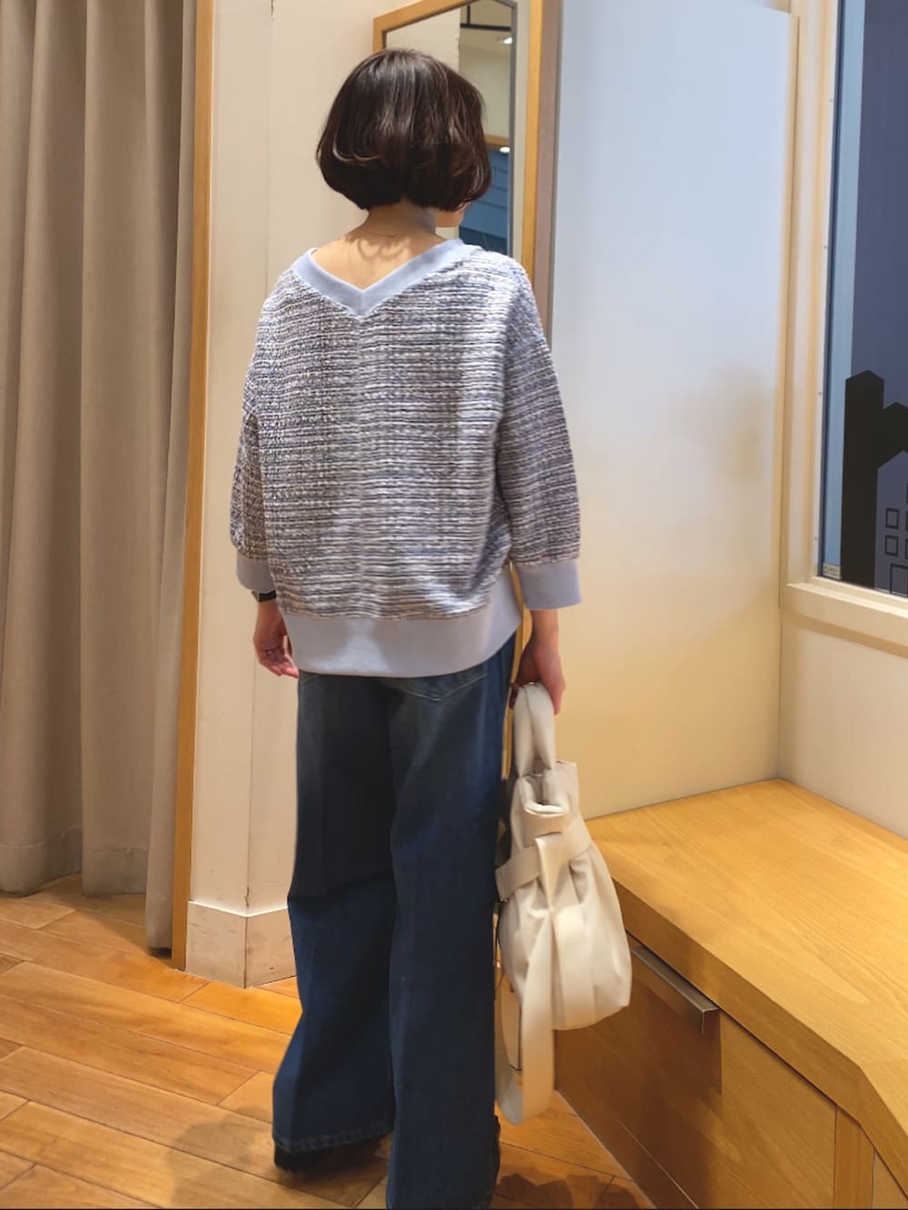 ブルー系のデニムパンツ、ブルー系のTシャツ/カットソー、ホワイト系のショルダーバッグを着用したレディースの春コーディネートの7枚目の写真