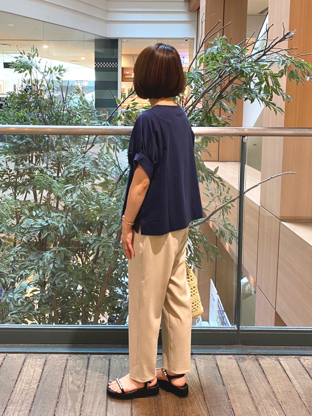 ブルー系のTシャツ/カットソー、ベージュ系のかごバッグ、ベージュ系のその他パンツを着用したレディースの夏コーディネートの6枚目の写真