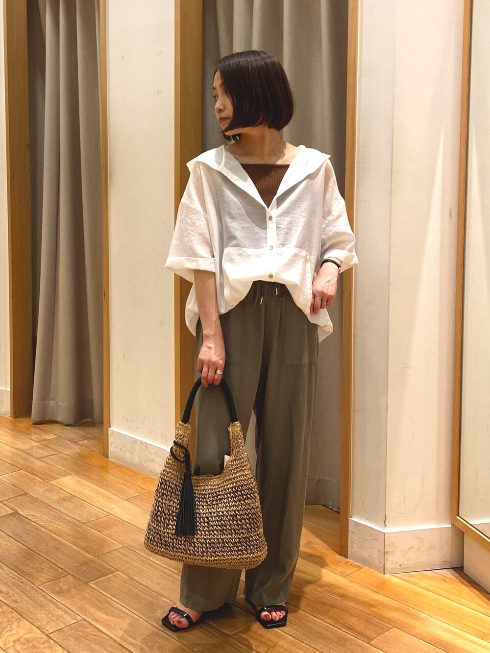 ホワイト系のシャツ/ブラウス、ブラウン系のTシャツ/カットソー、ブラウン系のかごバッグを着用したレディースの夏コーディネートの2枚目の写真