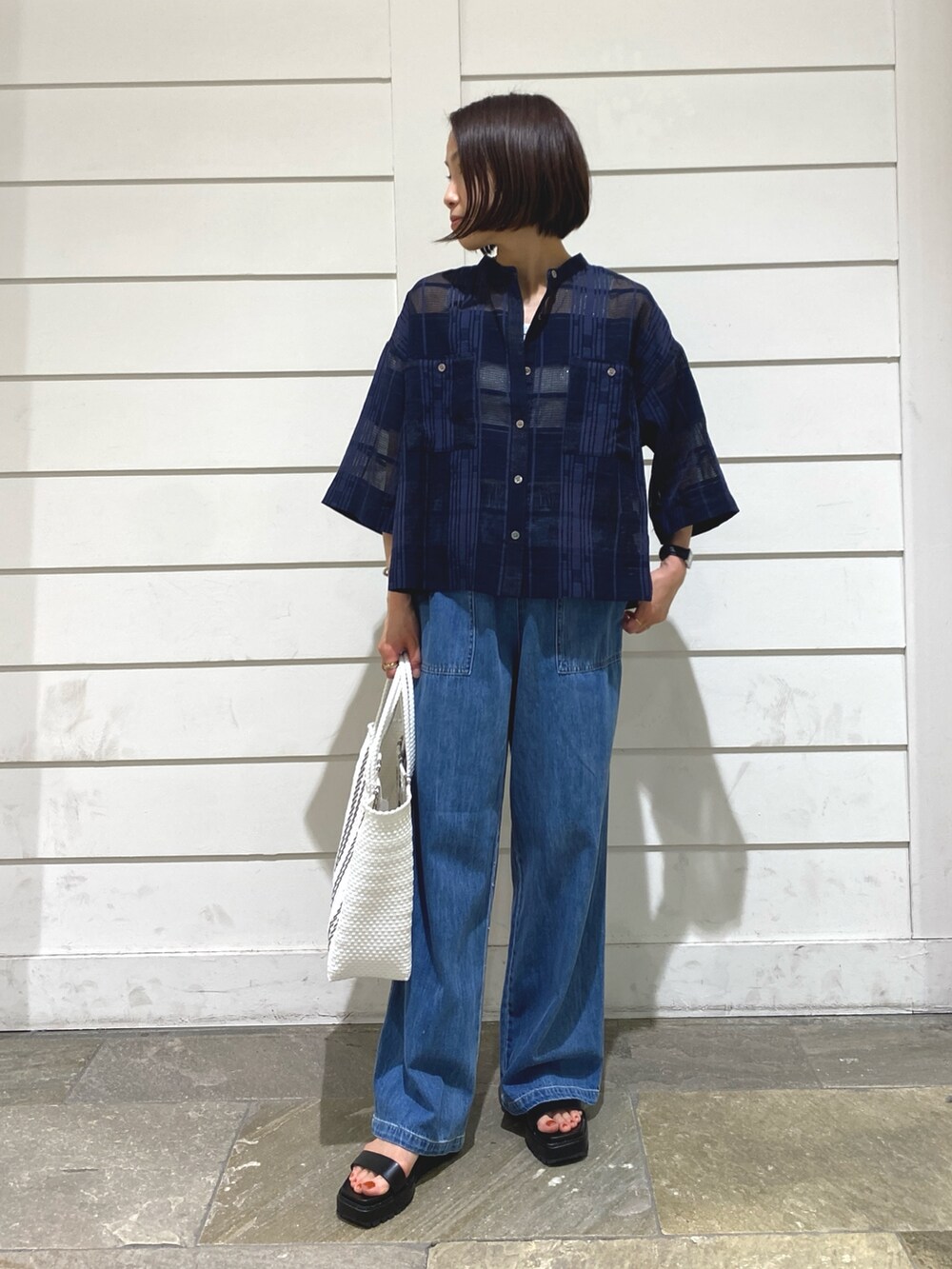 ブルー系のデニムパンツ、ブルー系のシャツ/ブラウス、ホワイト系のタンクトップを着用したレディースの夏コーディネートの2枚目の写真