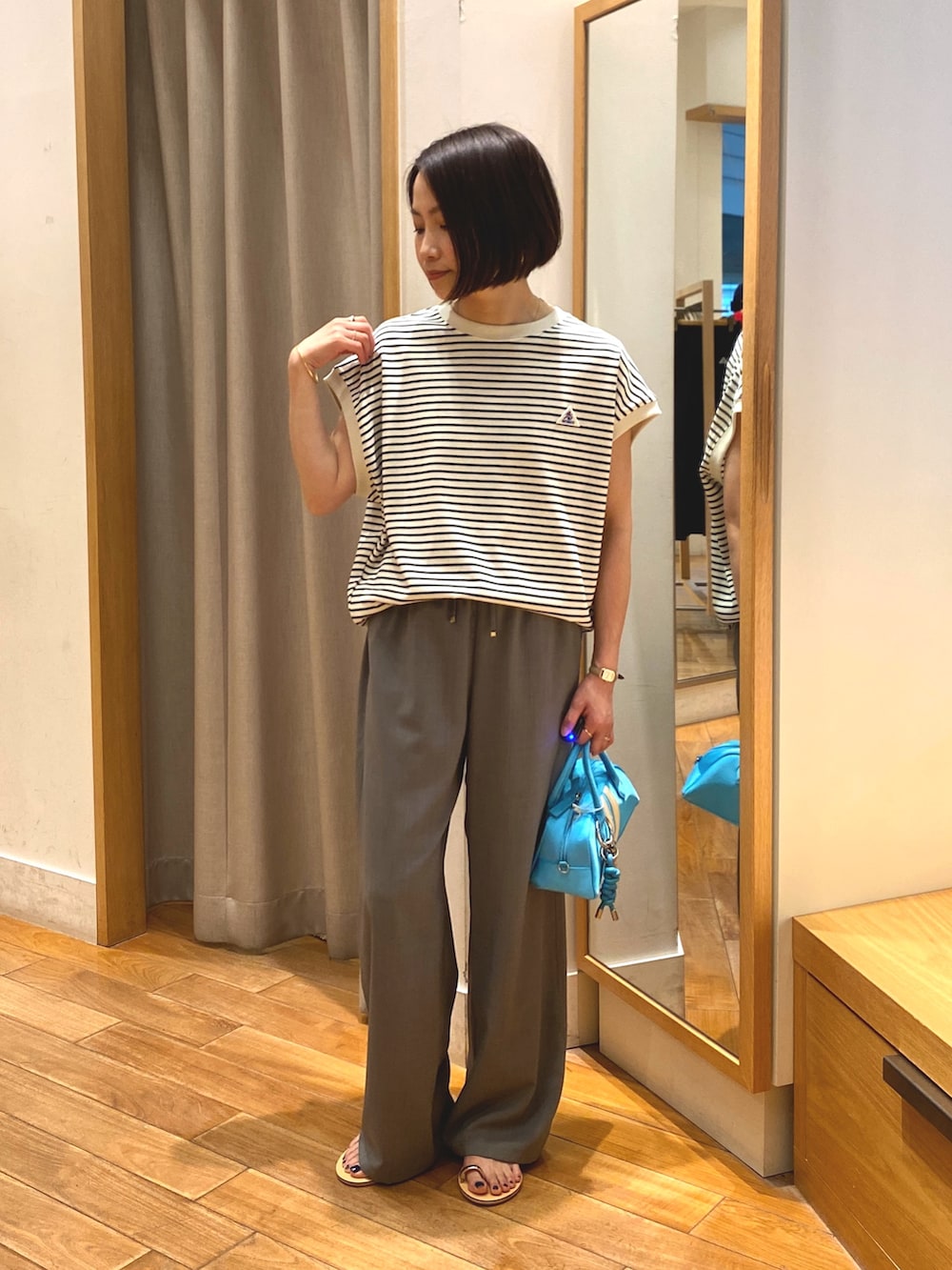 グレー系のその他パンツ、ブルー系のボストンバッグ、ホワイト系のTシャツ/カットソーを着用したレディースの春コーディネートの6枚目の写真