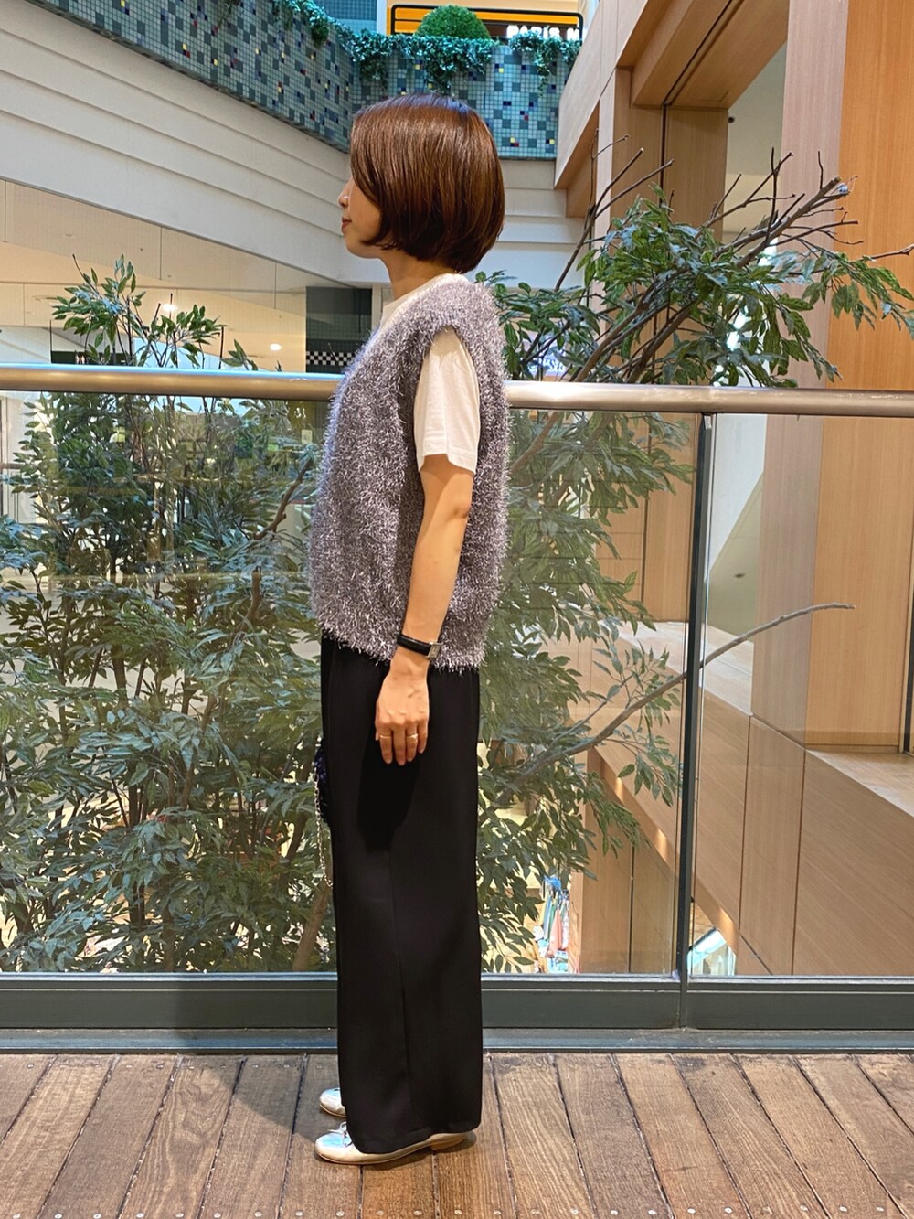 グレー系のベスト、ホワイト系のTシャツ/カットソー、ブラック系のその他パンツを着用したレディースの秋コーディネートの3枚目の写真