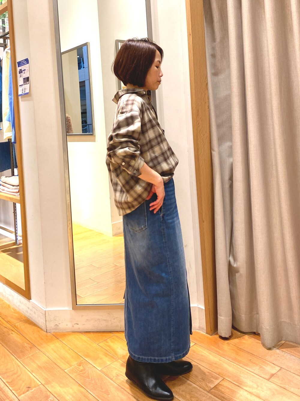 ブラウン系のシャツ/ブラウス、ブルー系のデニムスカート、ブラック系のショルダーバッグを着用したレディースの秋コーディネートの5枚目の写真