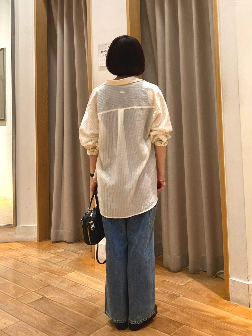 ブルー系のデニムパンツ、ブラック系のショルダーバッグ、ホワイト系のシャツ/ブラウスを着用したレディースの夏コーディネートの8枚目の写真