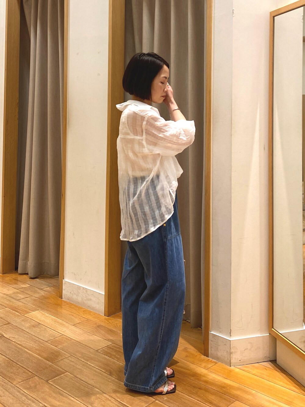 ブルー系のデニムパンツ、ベージュ系のトートバッグ、ホワイト系のシャツ/ブラウスを着用したレディースの春コーディネートの5枚目の写真