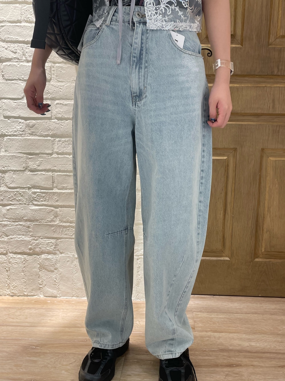 シルバー系のベスト、グレー系のTシャツ/カットソー、ブルー系のデニムパンツを着用したレディースの夏コーディネートの3枚目の写真