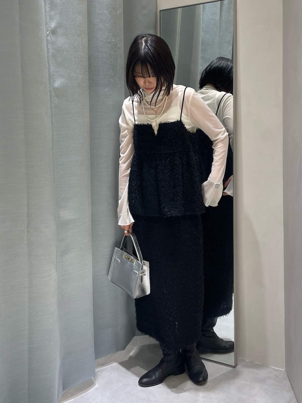 ブラック系のスカート、シルバー系のショルダーバッグ、ブラック系のキャミソールを着用したレディースの秋コーディネートの2枚目の写真