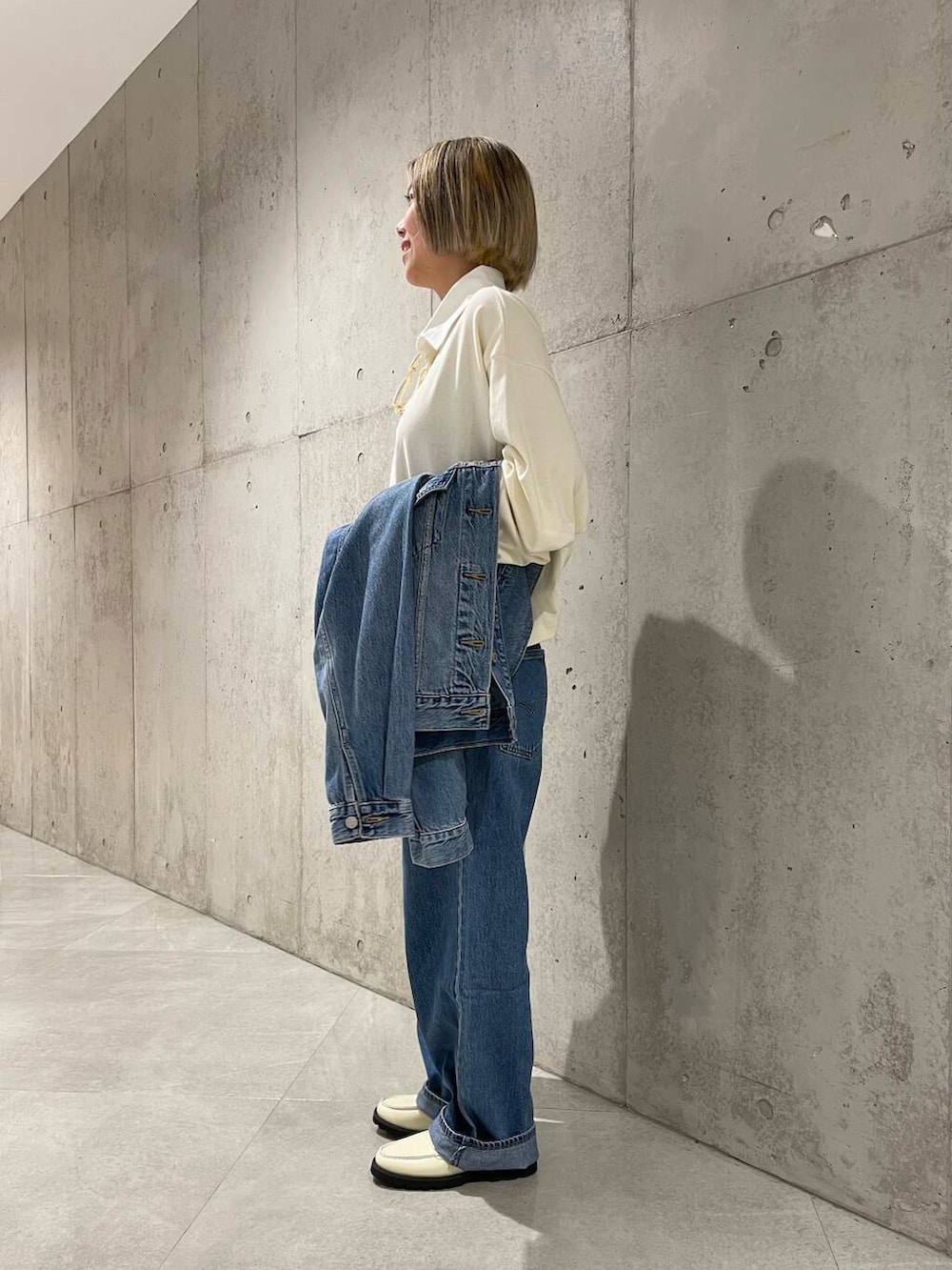 ベージュ系のショルダーバッグ、ホワイト系のローファー、ベージュ系のポロシャツを着用したレディースの夏コーディネートの2枚目の写真