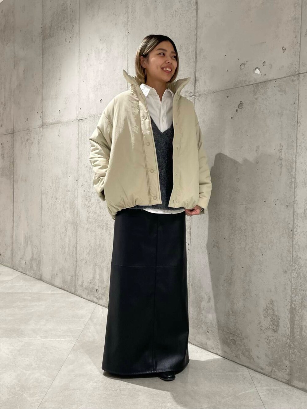 ベージュ系のブルゾン、グレー系のニット/セーター、ホワイト系のシャツ/ブラウスを着用したレディースの冬コーディネートの2枚目の写真