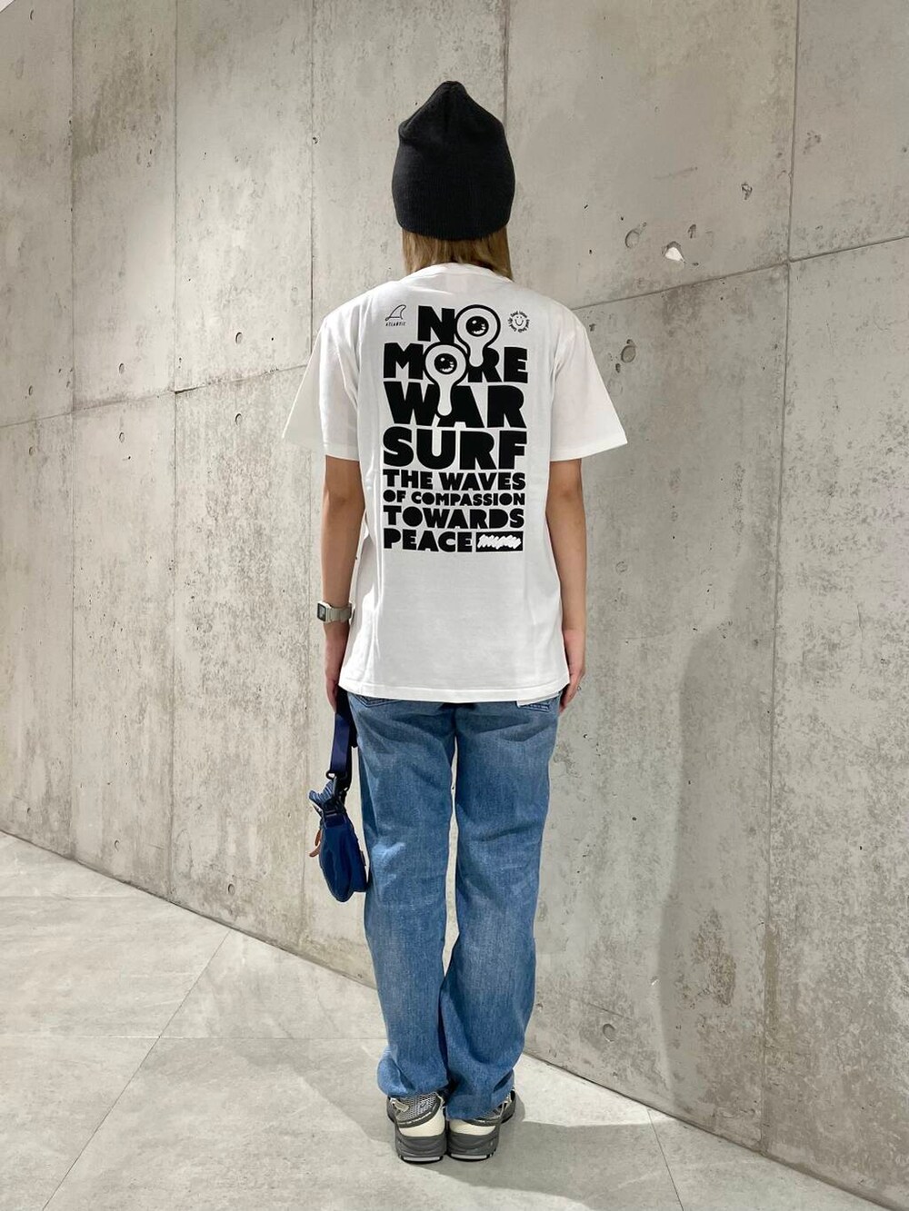 ブルー系のデニムパンツ、ブラック系のタンクトップ、ベージュ系のショルダーバッグを着用したレディースの春コーディネートの6枚目の写真